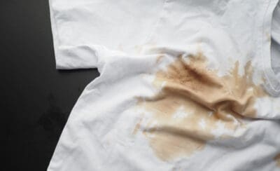 Camiseta branca com mancha de café.