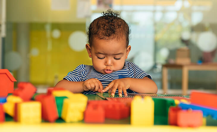 Bebê brincando com blocos coloridos.