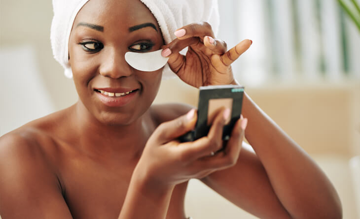 mulher negra colocando um adesivo na regiÃ£o das olheiras.