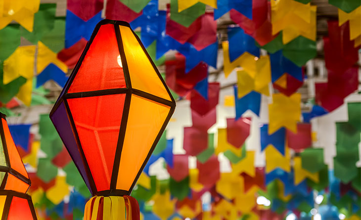 Bandeirinhas de festa junina e balões pendurados no teto.