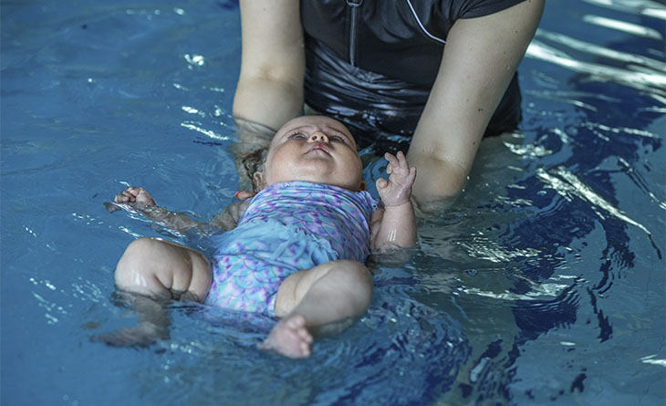 Bebê boiando na aula de natação.