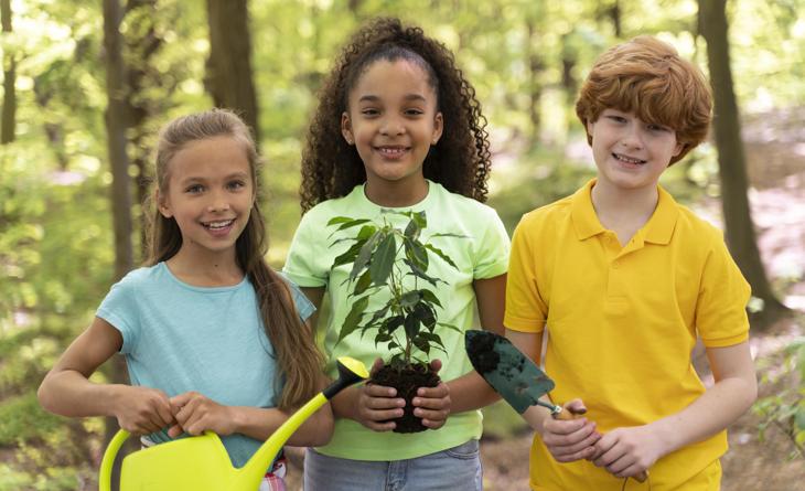 Sustentabilidade para crianças. Grupo de crianças segurando elementos de jardinagem.