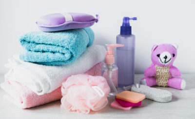 itens de higiene para crianças (como bucha, ursinhos, toalha) representando os melhores shampoos para bebe