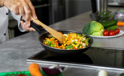 Pessoa dourando legumes na frigideira.