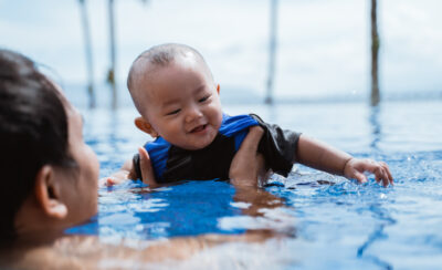 Mulher segurando um bebê na piscina de adulto.