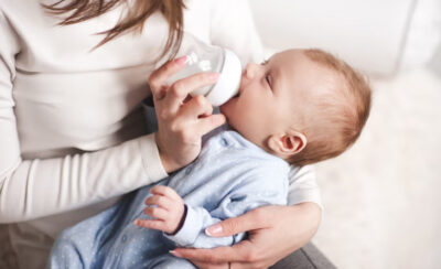 mãe dando mamadeira para bebê