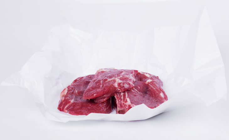 Pedaços de carne sobre papel manteiga.