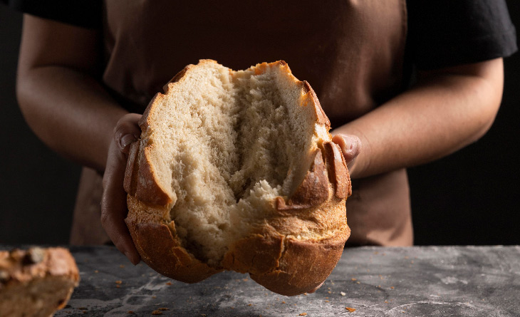 mãos segurando pão demonstrando como fazer pão caseiro