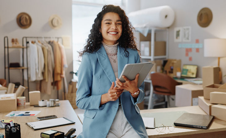 mulher segurando prancheta a frente de seu negócio para represenrar ideias para empreender com pouco dinheiro