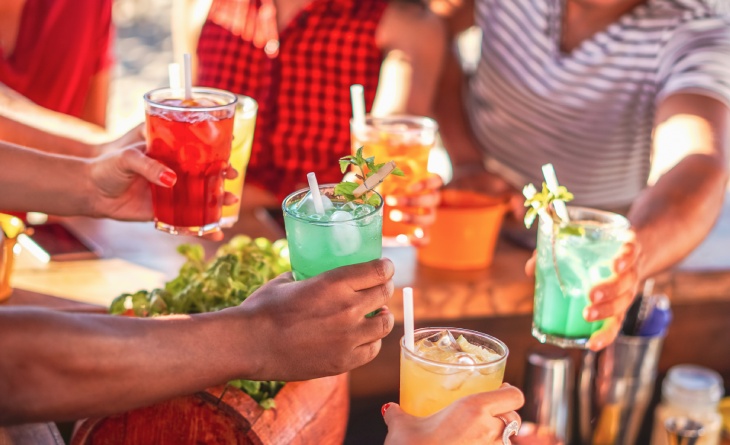 Pessoas brindando com copos de coquetéis.