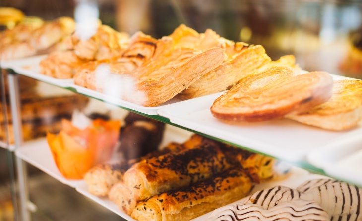 Vitrine de lanchonete com salgados e doces.