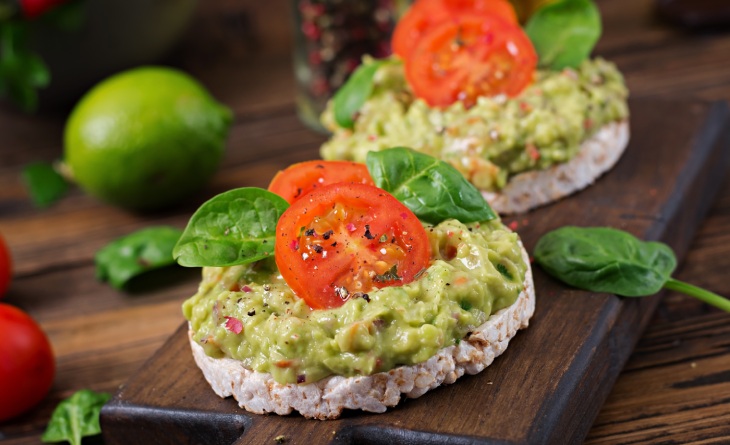 Guacamole em cima de biscoitos de arroz.