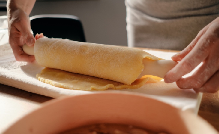 Massa de panqueca enrolada em rolo de abrir massa.