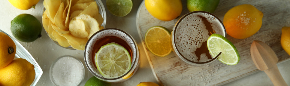 Drinks com cerveja e snacks, além dos ingredientes ao redor.