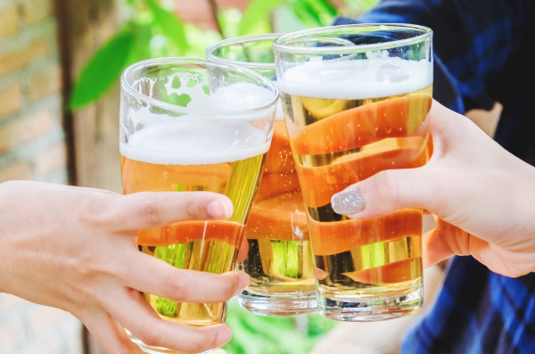 Três copos de cerveja brindando.