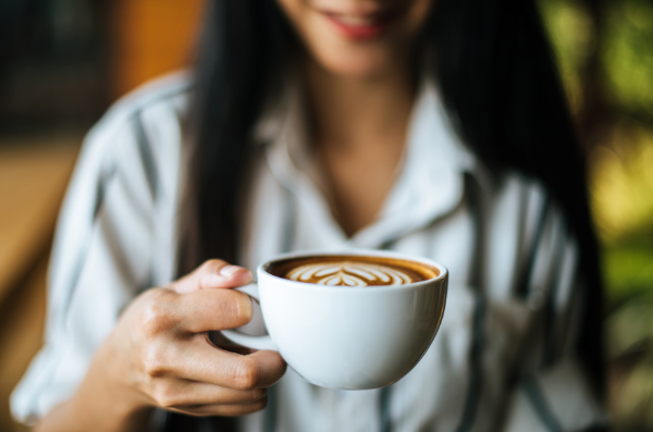 Mulher segurando xícara de café.