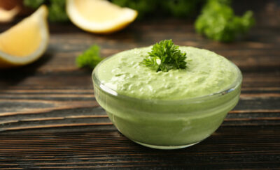 Pote de vidro pequeno com molho verde.