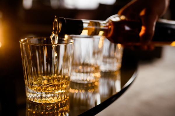 Whisky sendo colocado em copo.
