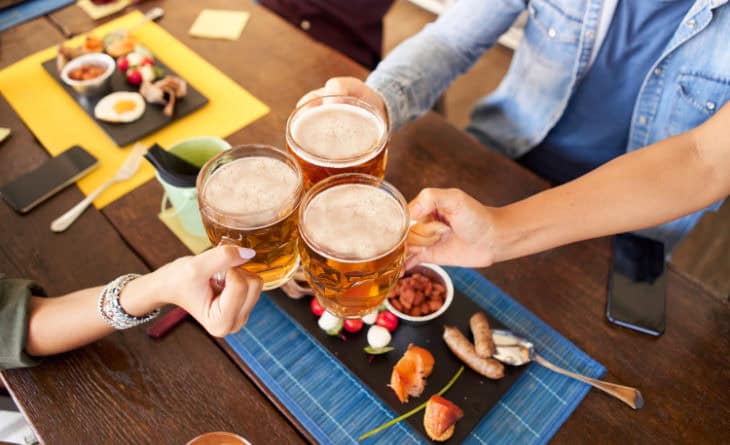 Grupo brindando com cervejas.