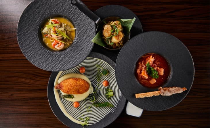 Pratos sofisticados de comida gourmet em louças pretas e brancas.