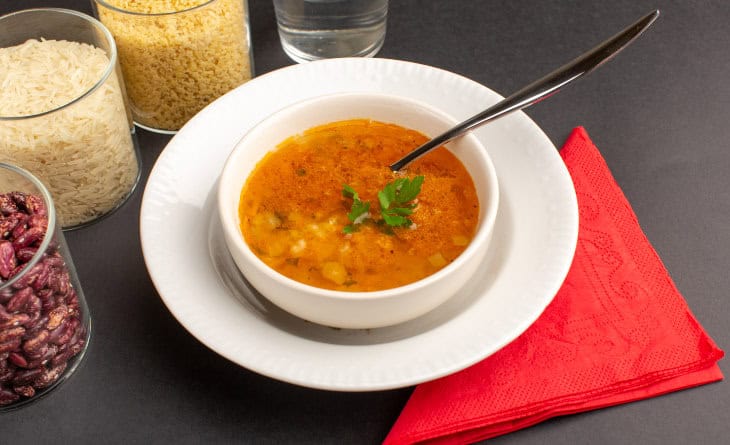 Caldo de mocotó em pote branco.